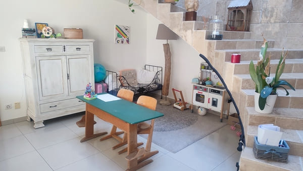 Coin enfant chaleureux avec bureau et espace de jeux dans le salon de la maison à vendre à Saint-Bernard