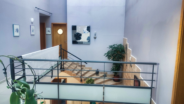 Passerelle mezzanine lumineuse donnant sur escalier central